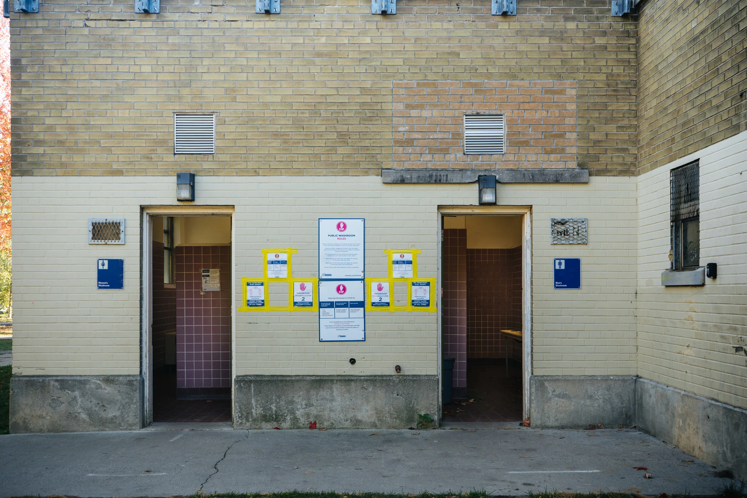 Photographed in Trinity Bellwoods, the exterior of the public bathroom is covered in Covid-19 signage. Even prior to the pandemic, public bathrooms served a vital need and had a pre-existing reputation of danger and risk. Accessibility has long been 