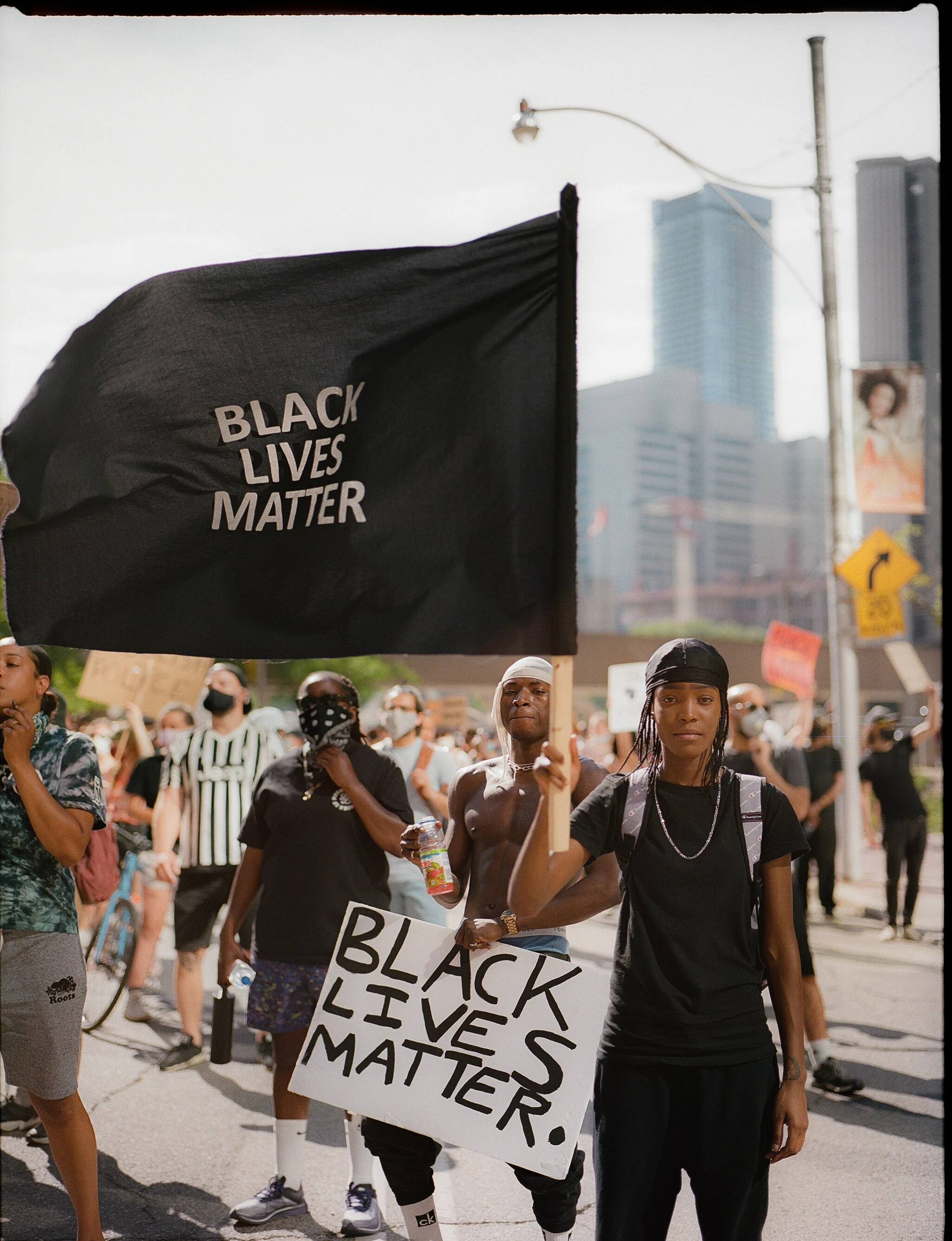 (1/2) COVID-19 collides with a pre-existing pandemic, the pandemic of racism and discrimination. In Toronto’s downtown core, a Black Lives Matter protest captures the intersection between a novel virus and the systemic racism and discrimination Black